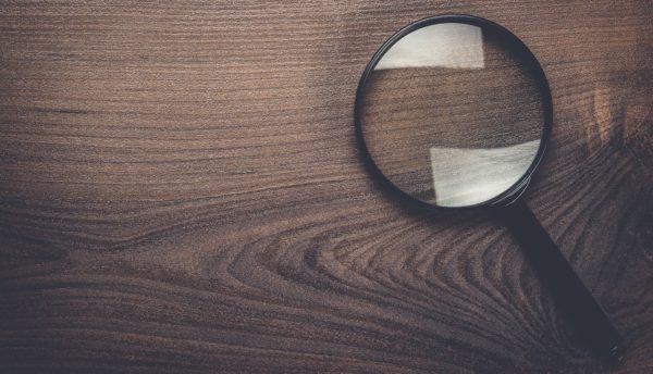 magnifying glass on the brown wooden background