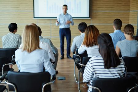 Businesspeople sitting in rows during lecture