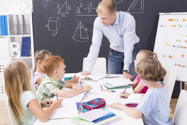 Shot of the math teacher talking with his students during math class