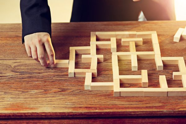 Man and wooden cubes on table. Management and marketing concepts